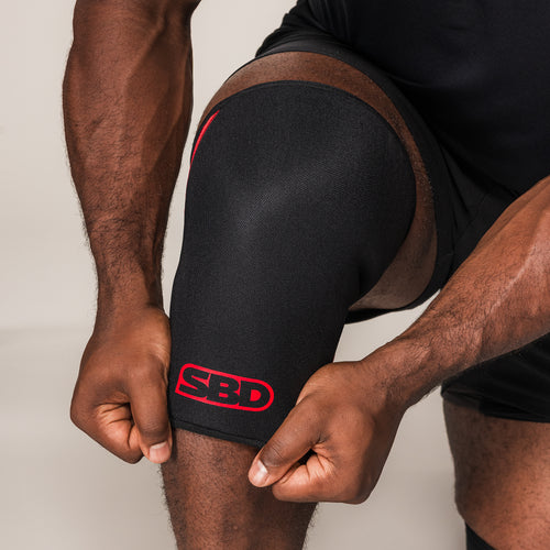 SBD Knee Sleeve, close-up of the black fabric, red stitching and logo