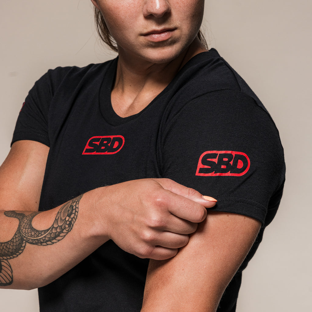 Women's black SBD Competition T-Shirt, close-up of the red sleeve logo