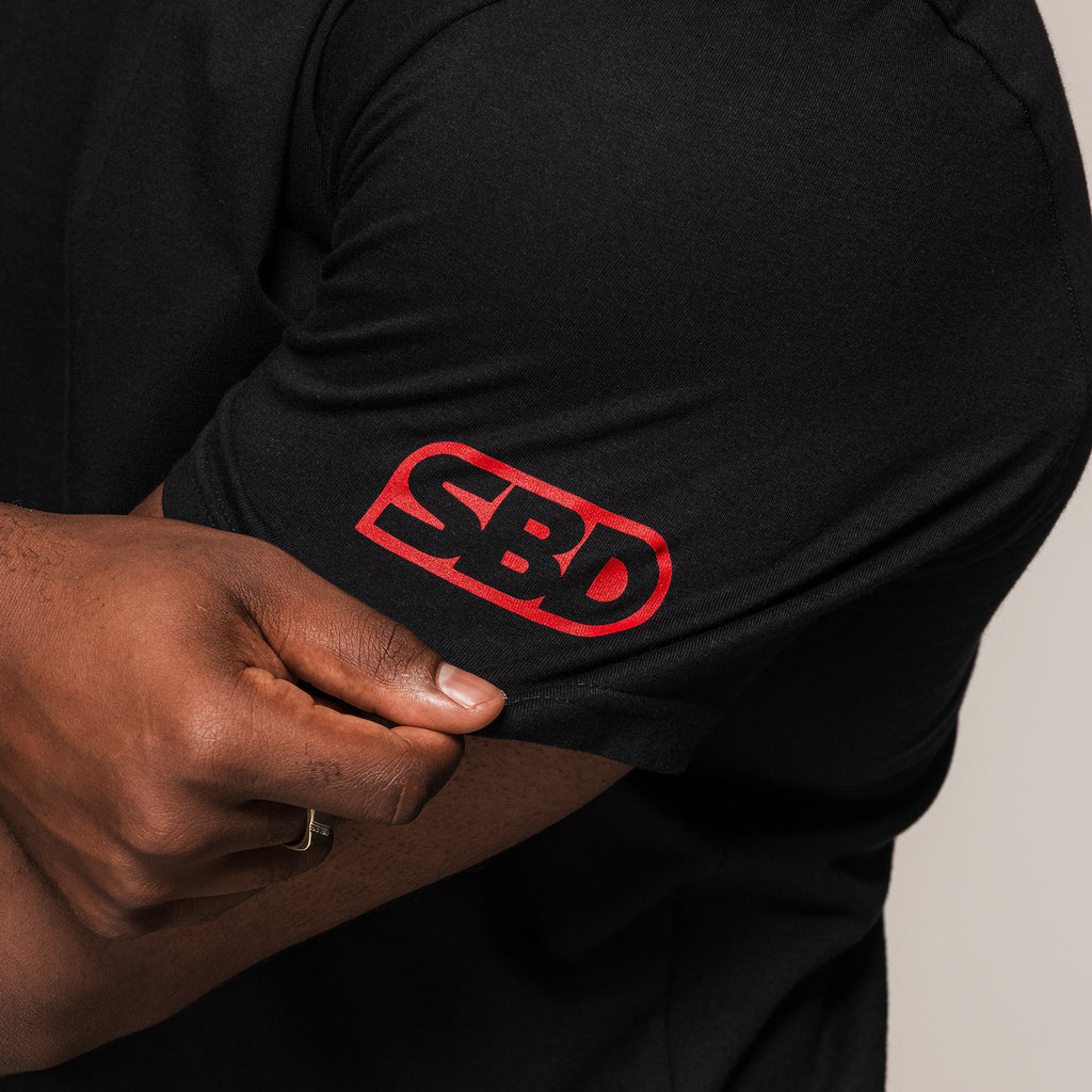 Men's black SBD Competition T-Shirt, close-up of the red sleeve logo