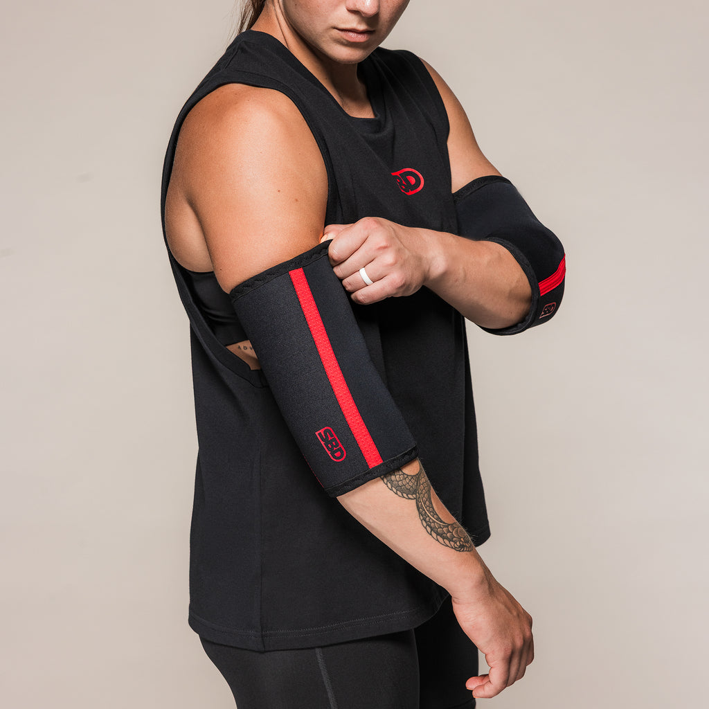 Athlete adjusting a black SBD Elbow Sleeve with red stripe