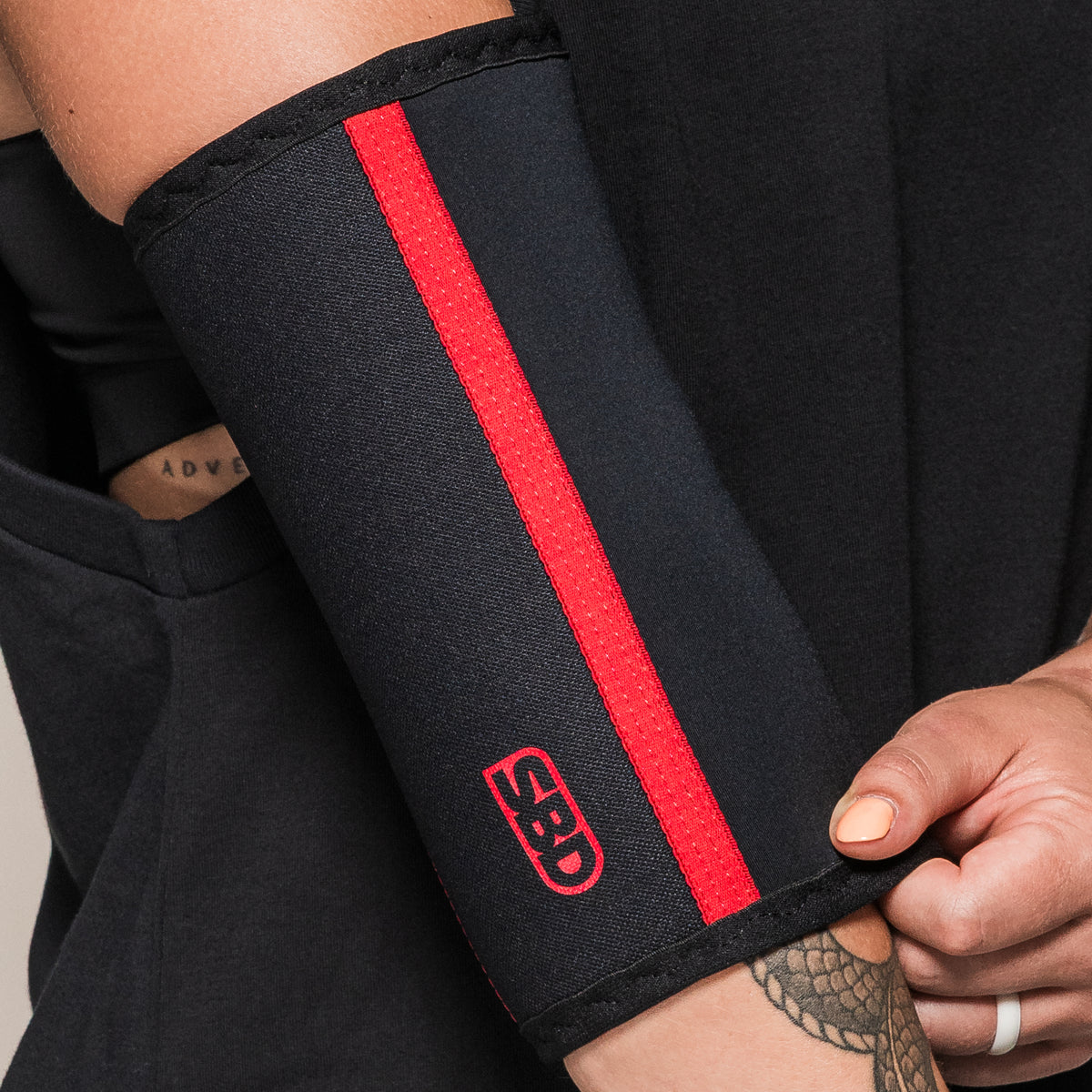 Black SBD Elbow Sleeve, close-up of the red stripe and logo