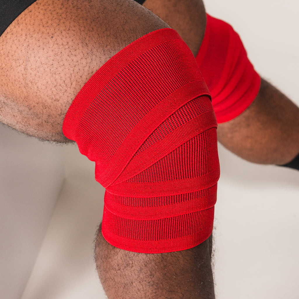 Red SBD Training Knee Wrap secured around a bent knee