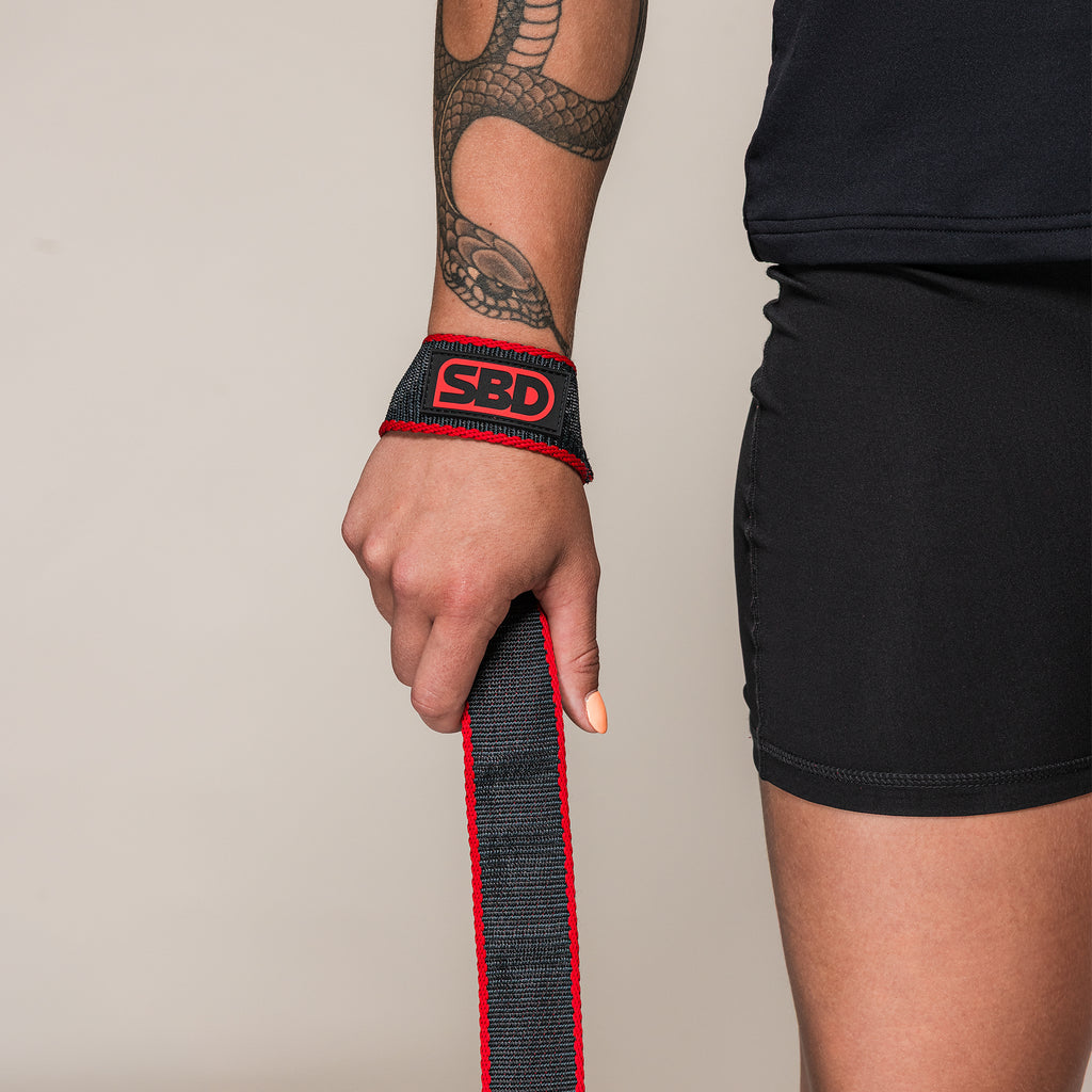 Black and red SBD Lifting Strap looped around an athlete's wrist