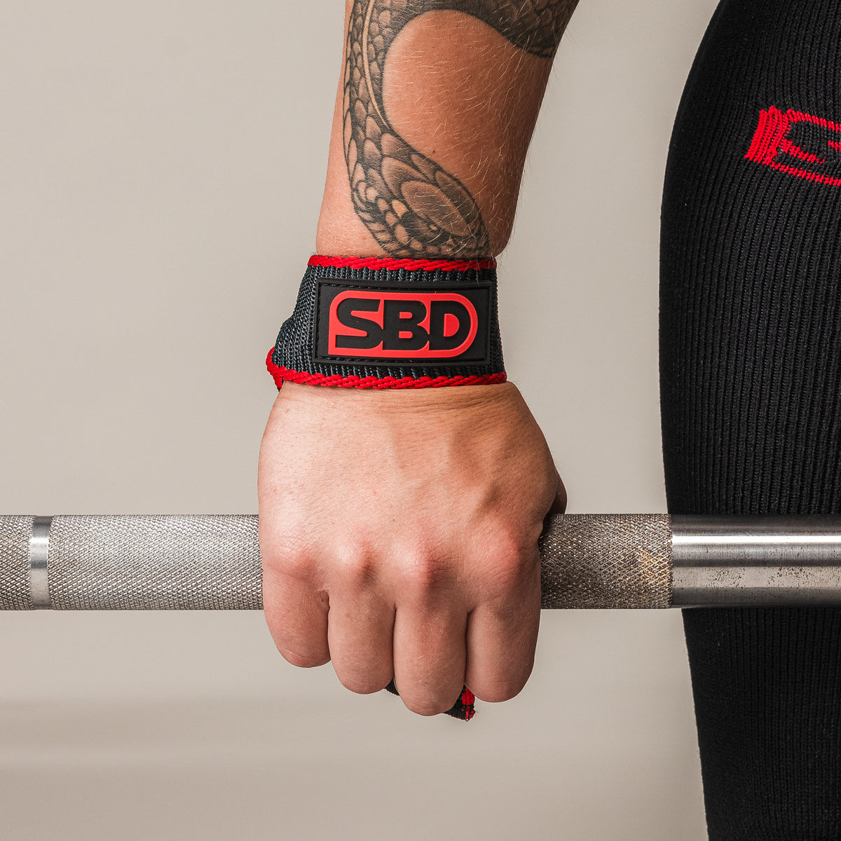Close-up of an SBD Lifting Strap securing the hand to a barbell