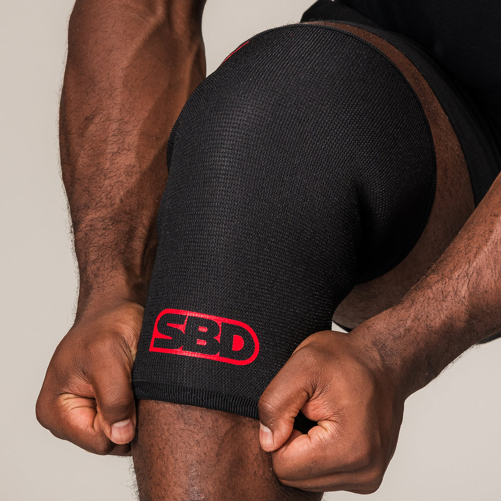 SBD Powerlifting Knee Sleeve, close-up of the black fabric and red logo