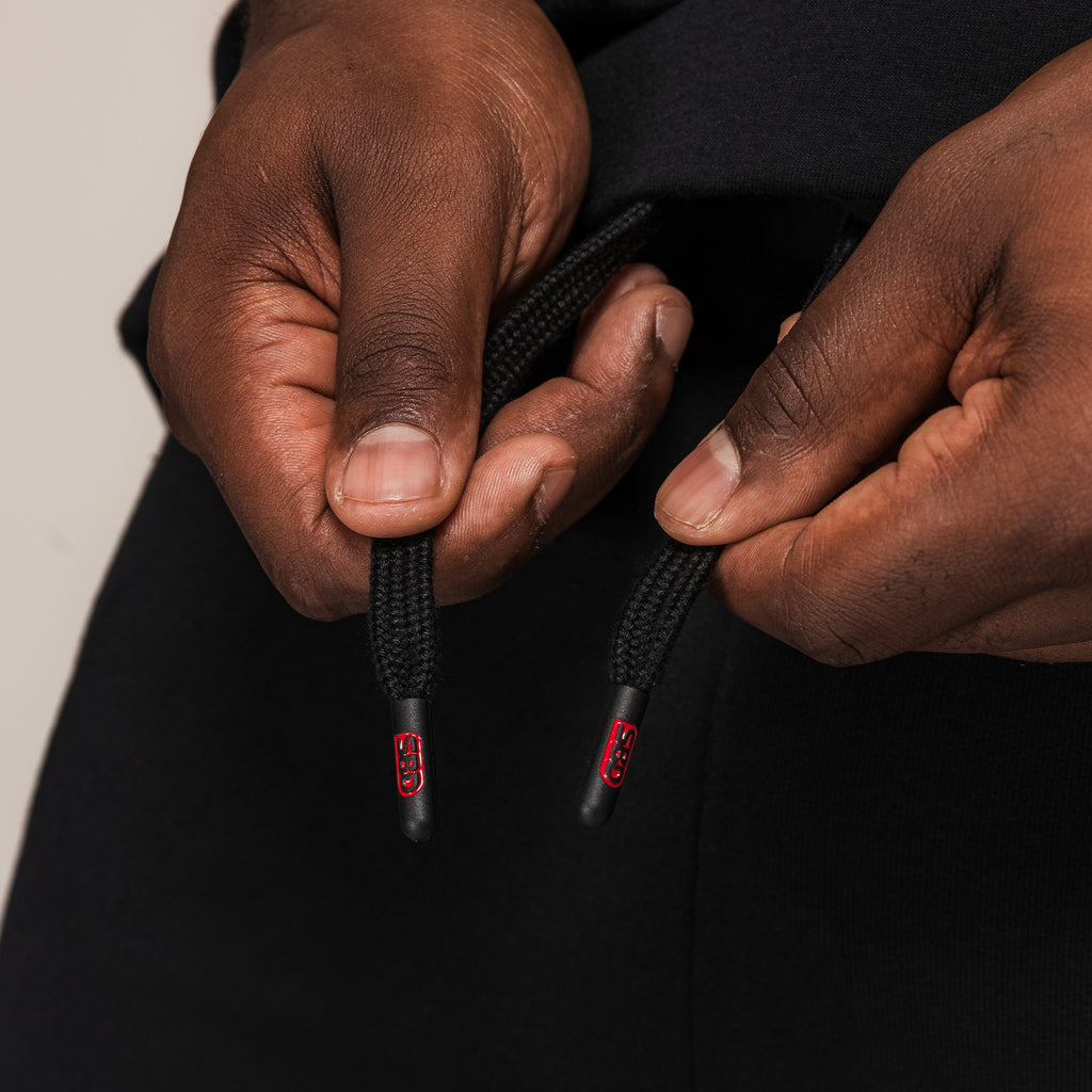 Men's black SBD Shorts, close-up of the branded drawstring ends