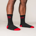 Black SBD Sports Socks with red logos and toes, front three-quarter view