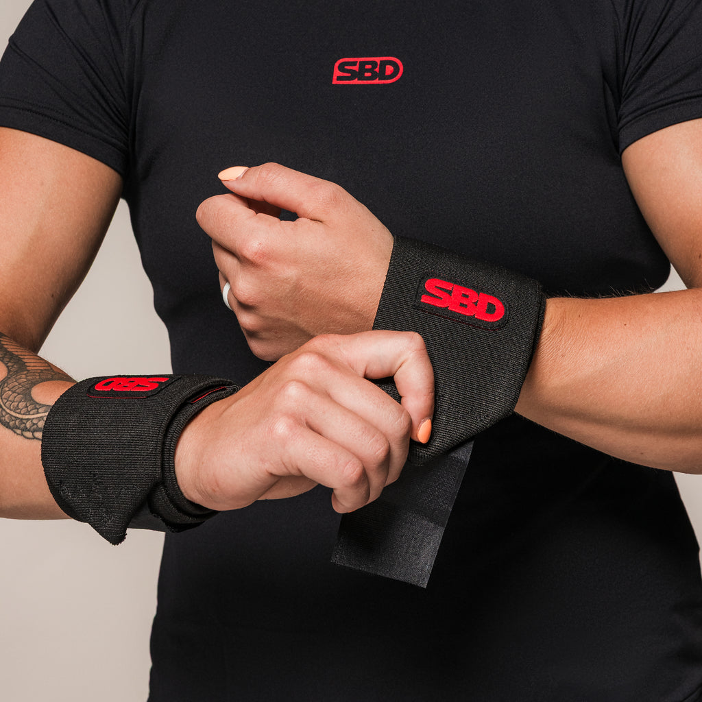 Black and red SBD Stiff Wrist Wraps, close-up of the fastening strap